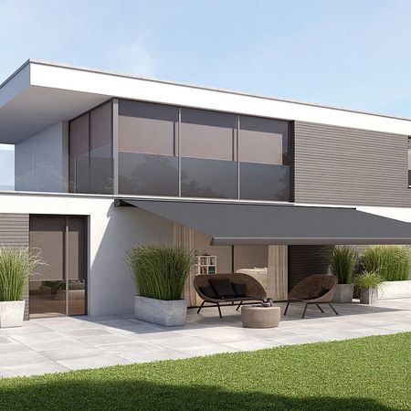 Modernes Haus mit großem Patio und gepflegtem Rasen, ideal für entspannte Stunden im Freien.