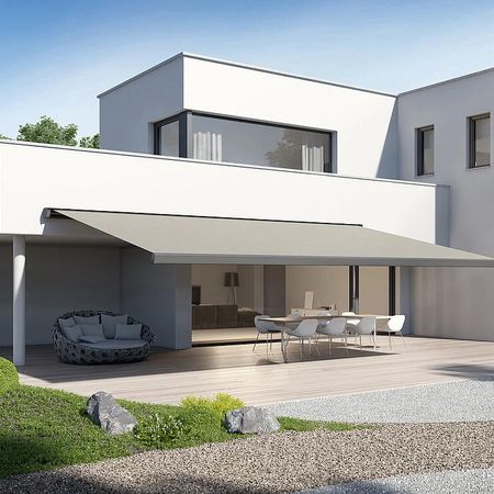 Modernes Haus mit großem Patio und gepflegtem Rasen, ideal für entspannte Stunden im Freien.