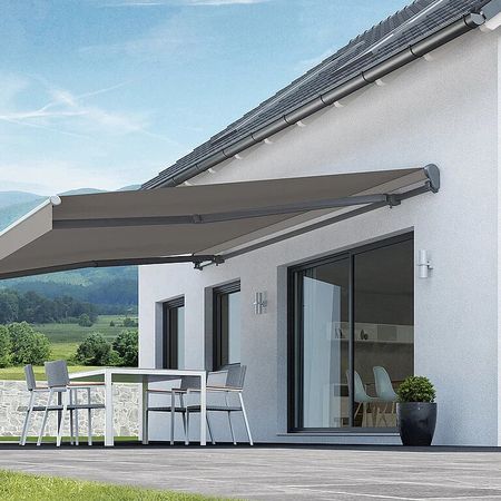 Ein Haus mit einer Terrasse und einem Terrassendach, das Schatten und Komfort im Freien bietet.