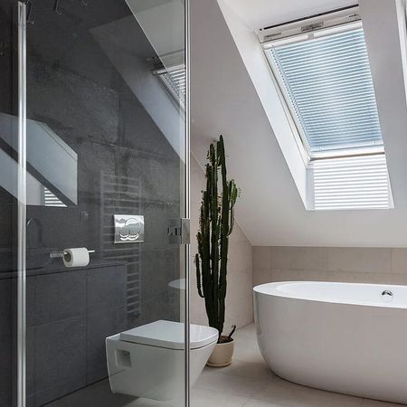 Modernes Badezimmer mit Jalousien an der Schräge