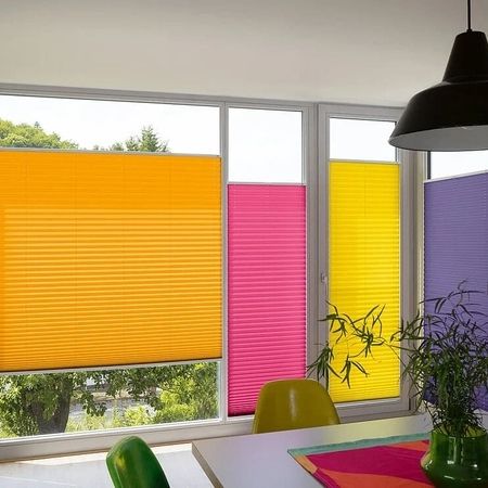 Ein einladendes Esszimmer mit bunten Jalousien an den Fenstern, die eine fröhliche Atmosphäre schaffen.